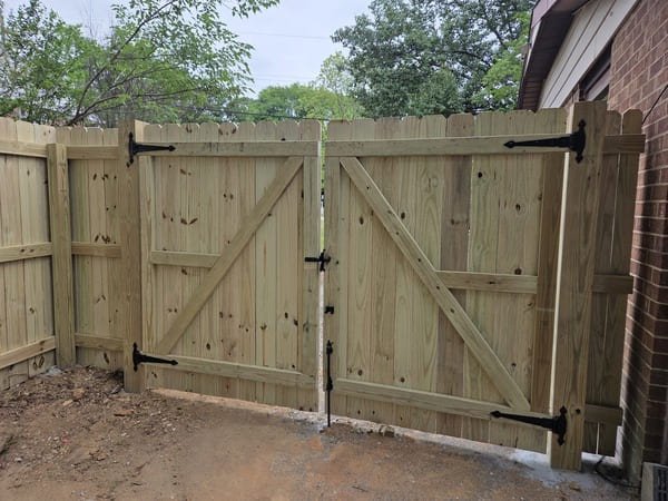 Custom wood double gate installation with heavy-duty hardware in Raleigh NC