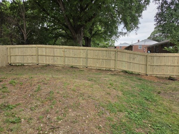 Full backyard wood privacy fence installation showing long property line in Raleigh NC